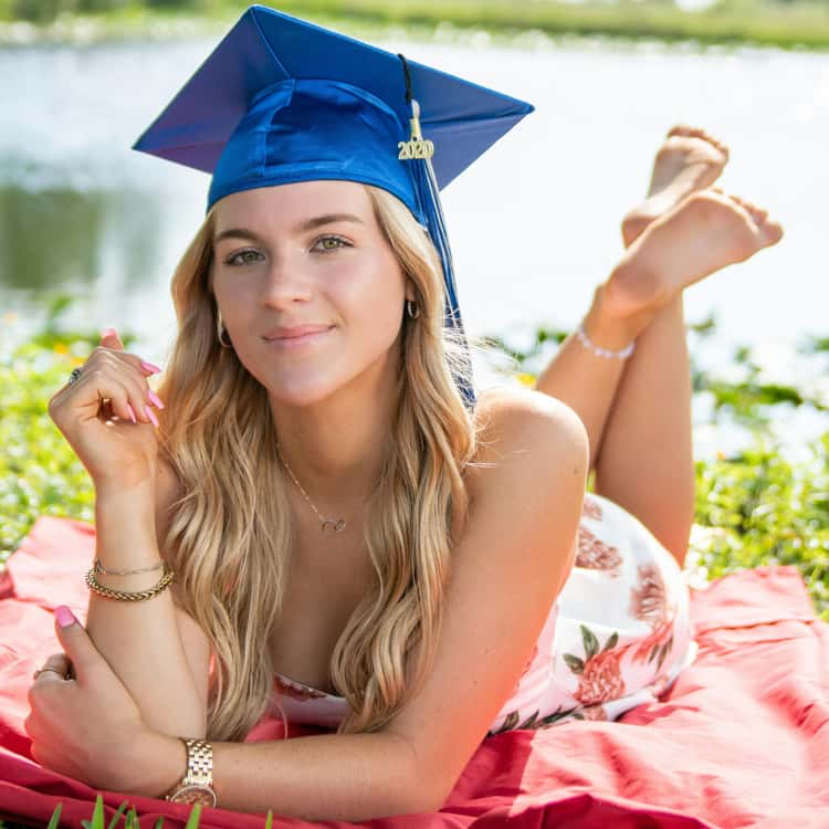 Portrait photo of a graduate laying down on a picnic blanket, for Coloring.app's AI photo-to-coloring page tool.