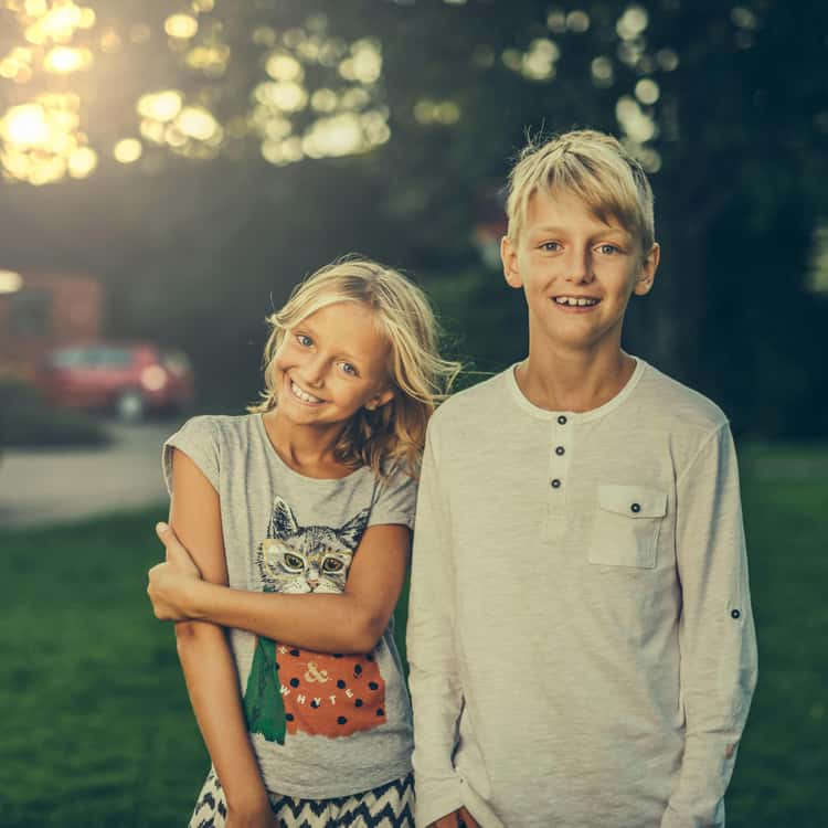 Portrait photo of a sister and her brother smiling to the camera, for Coloring.app's AI photo-to-coloring page tool.